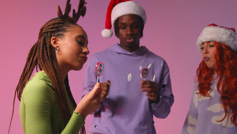 Studio-Shot-Of-Gen-Z-Friends-Dancing-At-Christmas-Party-Wearing-Santa-Hat-And-Reindeer-Antlers